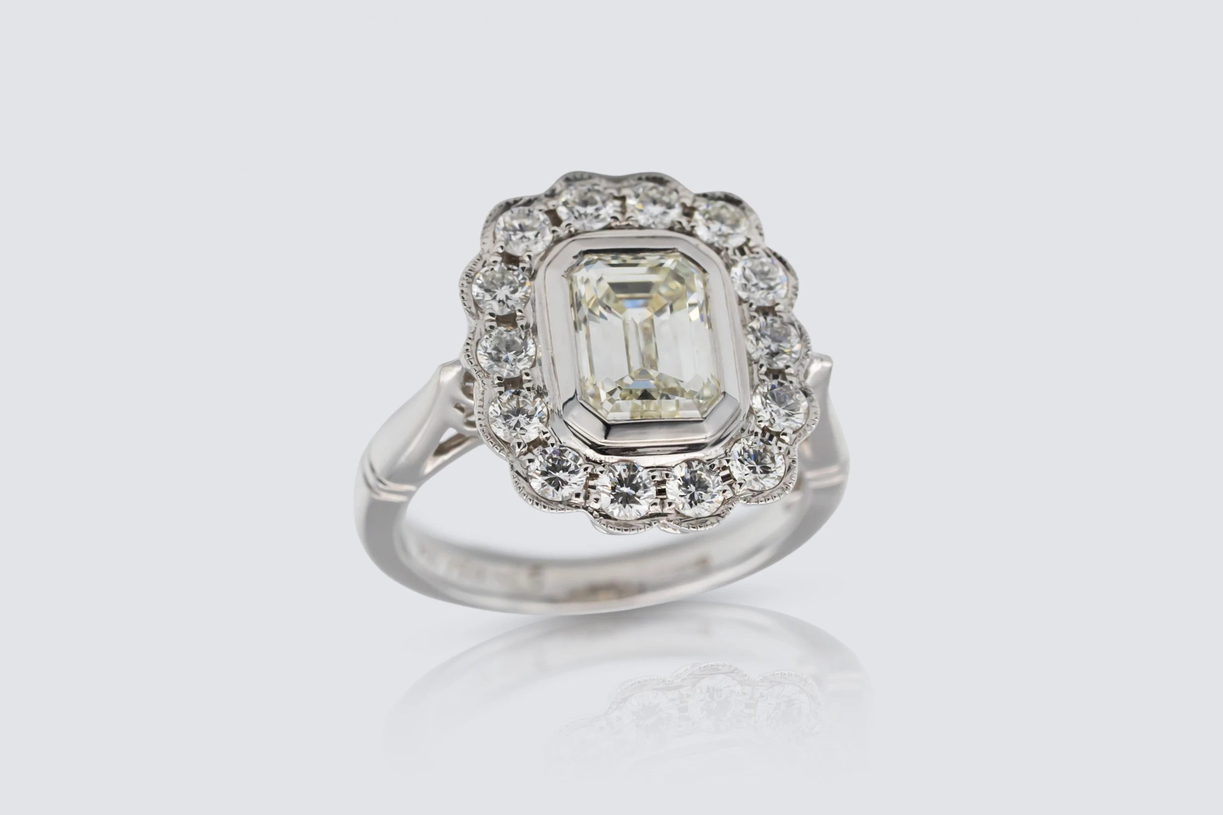 18ct White Gold 1.50ct Emerald and 0.65ct Diamond Rubover Halo Ring Size K