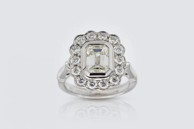 18ct White Gold 1.50ct Emerald and 0.65ct Diamond Rubover Halo Ring Size K